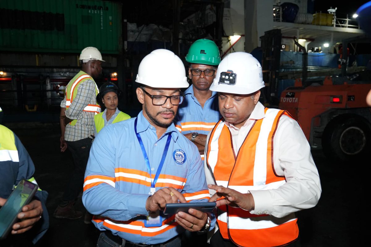 Minister within the Public Works Ministry Deodat Indar (right) conferring with a GPL official