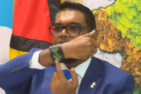 President Irfaan Ali holding up a band depicting the map of Guyana at a briefing he just held in St Vincent. 