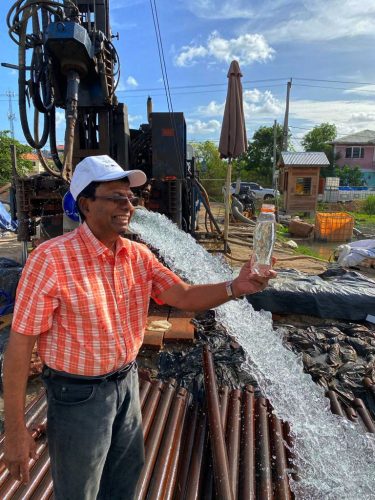 GWI Chief Executive Shaik Baksh with a bottle of water from the site (GWI photo)
