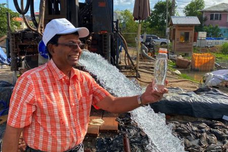 GWI Chief Executive Shaik Baksh with a bottle of water from the site (GWI photo)

