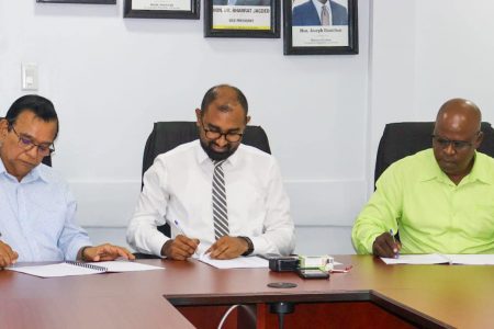 Chief Labour Officer, Dhaneshwar Deonarine (centre) and the executives from  GPL and the union affixing their signatures to the MOU.  (Ministry of Labour photo)