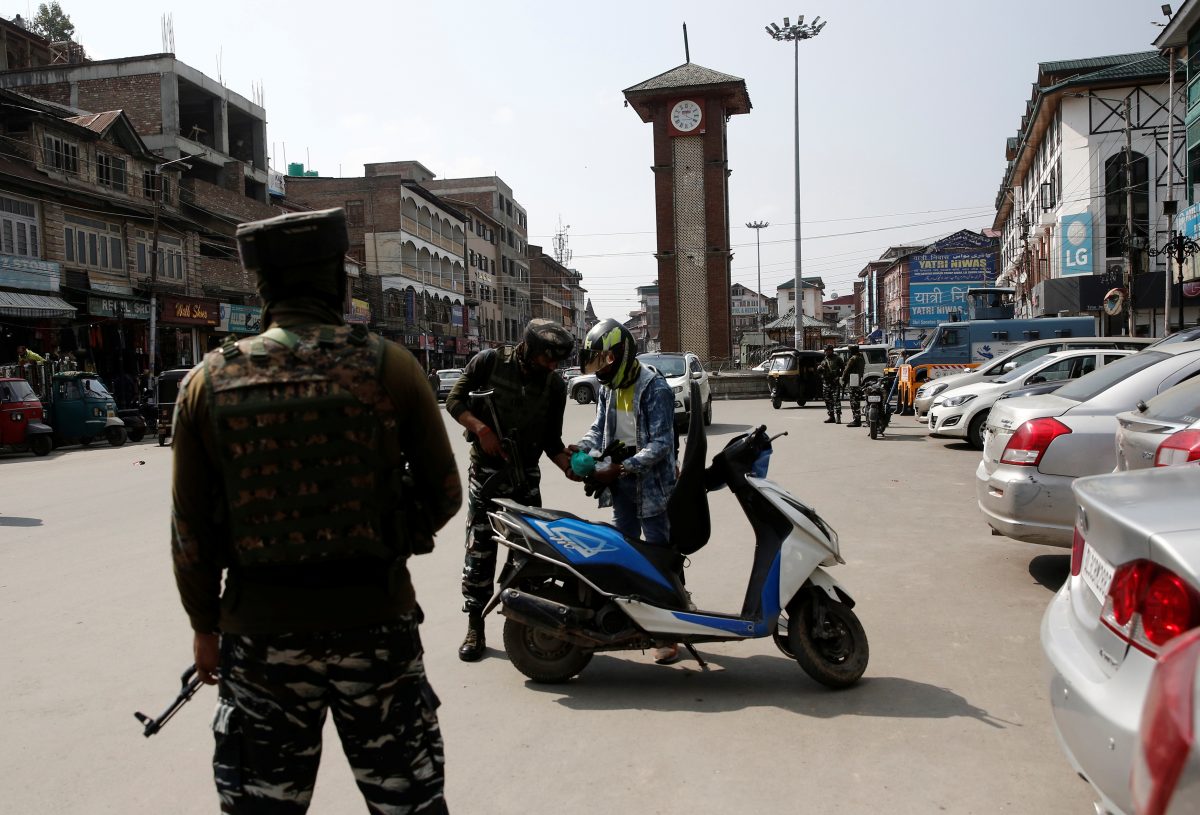 Indian Central Reserve Police Force (CRPF) personnel check the bags of a scooterist as part of security checking in Srinagar, October 12, 2021. REUTERS/Danish Ismail
