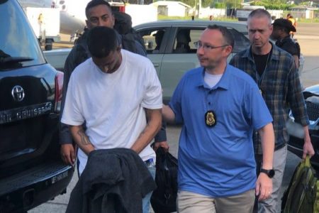 US Marshals and agents from the US Department of State Diplomatic Security Service escort Kim Maharaj at the Piarco International Airport on Wednesday for his extradition to the United States for a 1998 gang assault crime. (Photo courtesy US Embassy in T&T