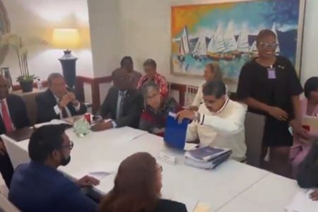 President Nicolas Maduro on Thursday in St Vincent with a stack of documents in from of him.
