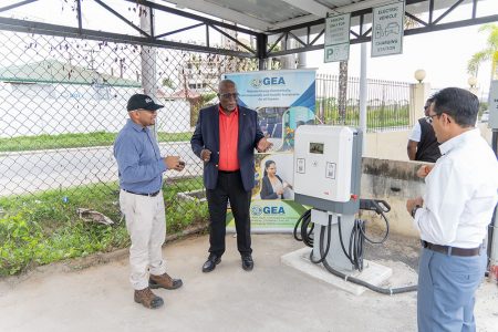 Prime Minister Mark Phillips (centre) at one of the charging stations (Office of the Prime Minister photo)