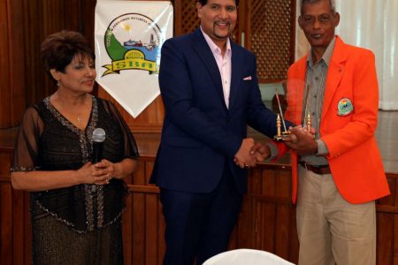 High Court judge Frank Seepersad, centre, presents an award to Captain Vallence Rambharat while San Fernando Business Association president Daphne Bartlett looks on.