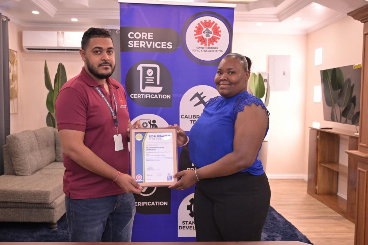 Manager of Atlantic Suites Luxury Apartments, Sharay McKenzie (right) receiving her certificate from GNBS Technical Officer, Latchman Mootoosammi. (GNBS photo)