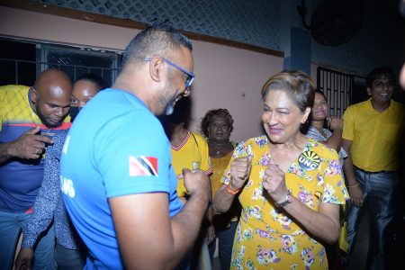 UNC Political Leader, Kamla Persad Bissessar, left, interacts with a supporter after the party’s Monday night meeting.