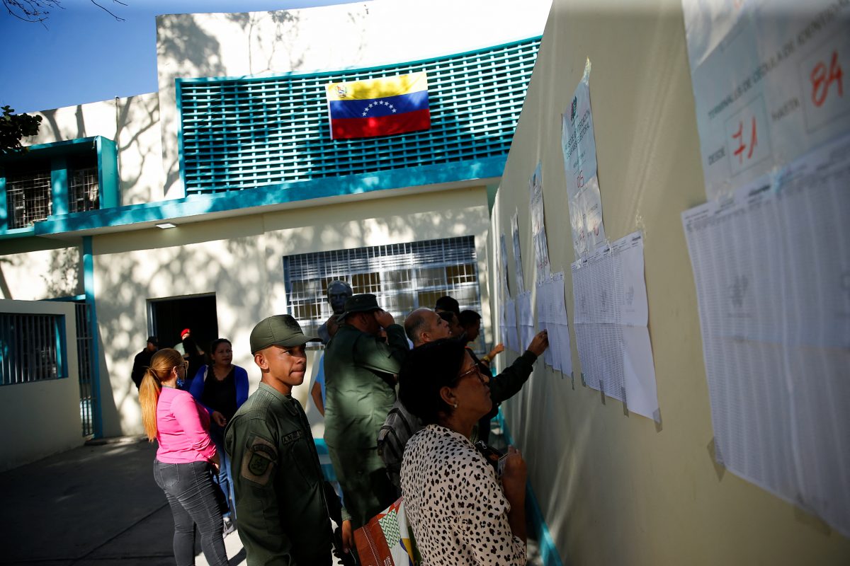 People look at the electoral lists on the day of an electoral referendum over Venezuela's rights to the potentially oil-rich region of Esequiba in Guyana, in Caracas, Venezuela December 3, 2023. REUTERS/Leonardo Fernandez Viloria