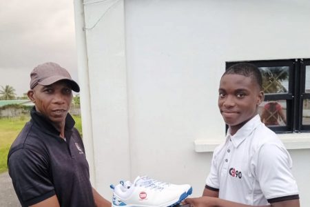 Shamar Apple (right) receiving the donation from Shawn Massiah, which was facilitated by the ‘Cricket Gear for Young and Promising Cricketers in Guyana’ project.