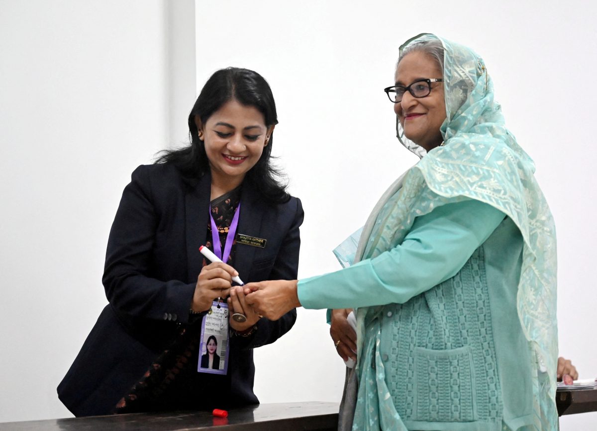 An officer puts an ink mark on the thumb of Sheikh Hasina, Prime Minister of Bangladesh and Chairperson of Bangladesh Awami League, at the Dhaka City College center during the 12th general election in Dhaka, Bangladesh, January 7, 2024. REUTERS/Handout provided by Prime Minister's office/Handout via REUTERS