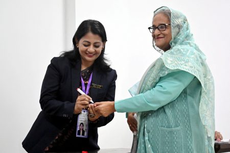 An officer puts an ink mark on the thumb of Sheikh Hasina, Prime Minister of Bangladesh and Chairperson of Bangladesh Awami League, at the Dhaka City College center during the 12th general election in Dhaka, Bangladesh, January 7, 2024. REUTERS/Handout provided by Prime Minister's office/Handout via REUTERS
