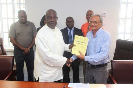Former Chief Education Officer, Ed Caesar (left) submitting the preliminary report on the Education Sector to then Minister of Education, Dr Rupert Roopnaraine  on April 28 2017. (SN file photo)
