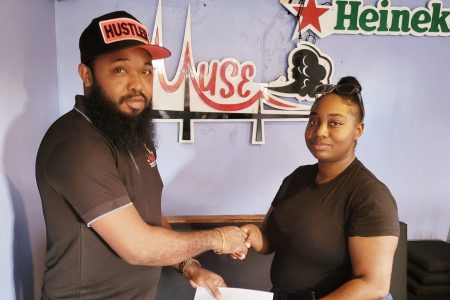 Supervisor of Muse Hookah Bar, Kevin ‘Chelsea’ Evans (left), hands over the sponsorship cheque to Khashana Yhap
