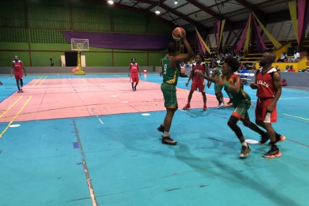 Action in the ‘One Guyana’ Basketball League Playoffs between the Eagles (red) and UG Trojans