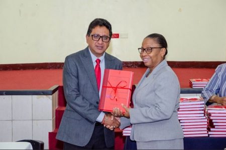 Minister of Legal Affairs and Attorney General, Anil Nandlall SC (left), handing over the Criminal Bench Books to Chief Justice (Ag), Roxane George SC (DPI photo) 