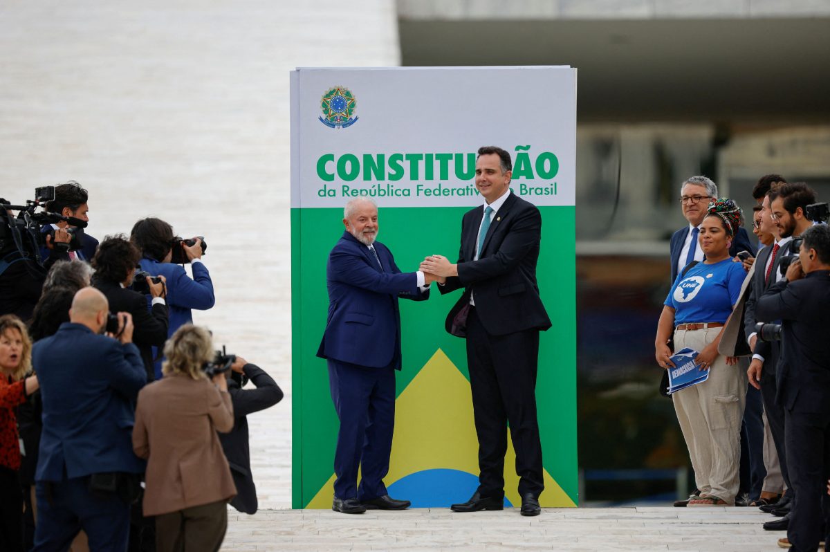 Brazil's President Luiz Inacio Lula da Silva (left) and Brazil's Senate President Rodrigo Pacheco pose for a picture next to a banner representing the Brazilian constitution in front of the National Congress after an event to mark the consolidation of democracy in Brazil, a year after supporters of far-right former President Jair Bolsonaro stormed the presidential palace, Congress and Supreme Court, in Brasilia, Brazil January 8, 2024. REUTERS/Adriano Machado 