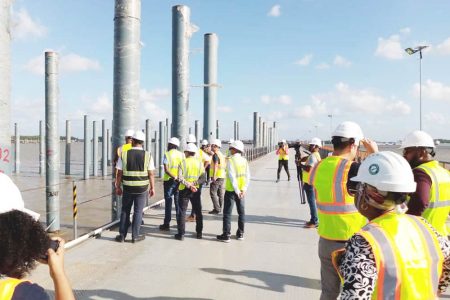 Members of the media and representatives from Polytechnica inspecting work on the 100 percent completed temporary structure of the Demerara Harbour Bridge