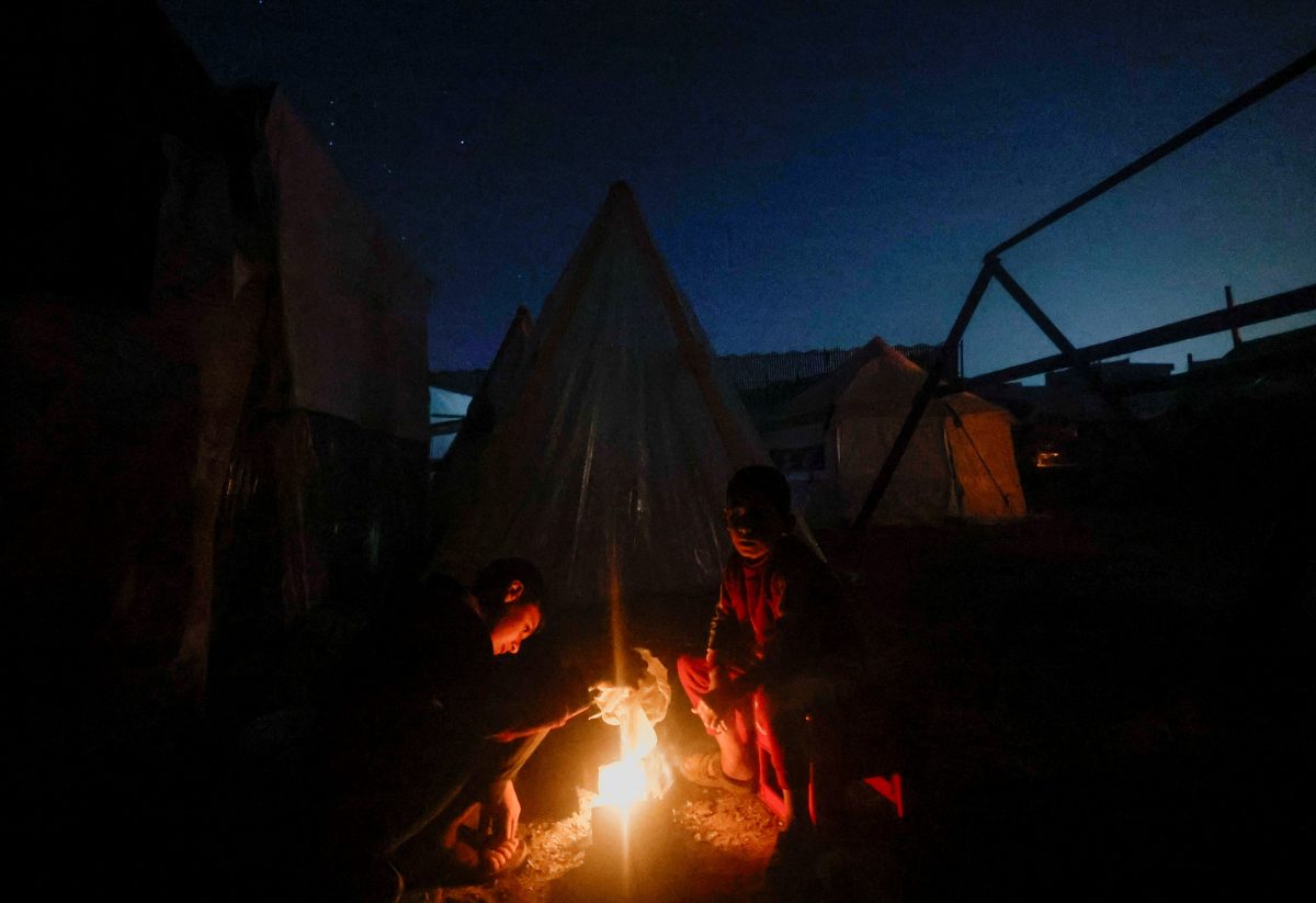 Palestinians who fled their houses due to Israeli strikes sit by a tent, amid the ongoing conflict between Israel and the Palestinian Islamist group Hamas, in Rafah, in the southern Gaza Strip, January 1, 2024. REUTERS/Mohammed Salem