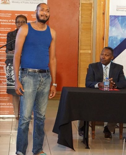 Ministry of Public Administration permanent secretary Claudelle Mc Kellar, right, looks on as a model shows what is acceptable wear during a Dress Code Policy presentation at Old Fire Station Building, Port-of-Spain, yesterday.