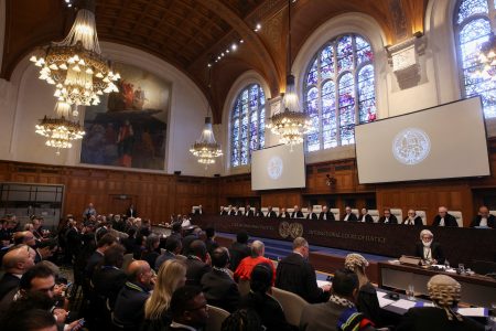 People sit inside the International Court of Justice (ICJ) on the day of the trial to hear a request for emergency measures by South Africa, who asked the court to order Israel to stop its military actions in Gaza and to desist from what South Africa says are genocidal acts committed against Palestinians during the war with Hamas in Gaza, in The Hague, Netherlands, January 11, 2024. REUTERS/Thilo Schmuelgen