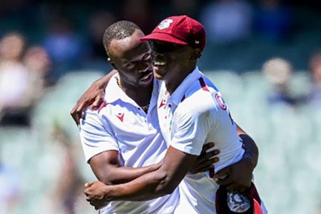  Kemar Roach (left) celebrates a wicket with Shamar Joseph during the opening Test in Adelaide