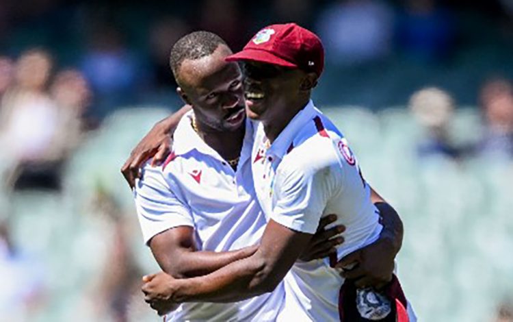  Kemar Roach (left) celebrates a wicket with Shamar Joseph during the opening Test in Adelaide