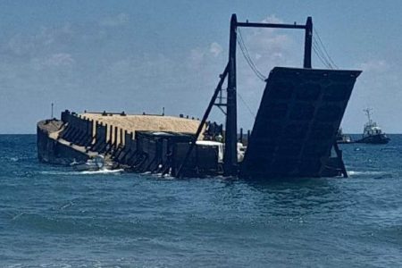 The barge carrying aggregate that residents of Hope Beach and environs say is listing badly and is now in danger of sinking.