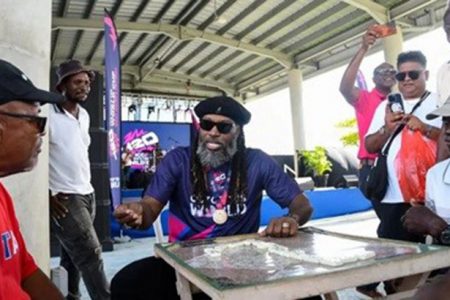 Chris Gayle (centre) plays dominoes during the ICC Men’s T20 World Cup promotional event on Thursday in Barbados. (ICC)