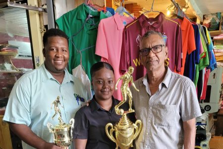 Samarca Evelyn of Sports Management Inc. displaying the second-place accolade alongside Cedric Payne (left) of Cedric Imports and Ramesh Sunich (right) of Trophy Stall.