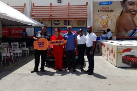 Yara Smith posing with the General Manager and members of the Massy team while receiving her grand prize