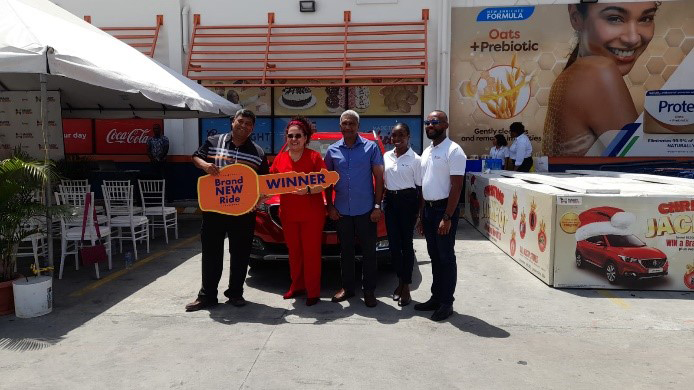 Yara Smith posing with the General Manager and members of the Massy team while receiving her grand prize