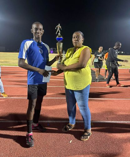 Pouderoyen captain Darrel Abrams collecting the championship trophy from WDFA acting president Christine Schmidt.