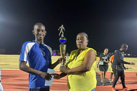 Pouderoyen captain Darrel Abrams collecting the championship trophy from WDFA acting president Christine Schmidt.