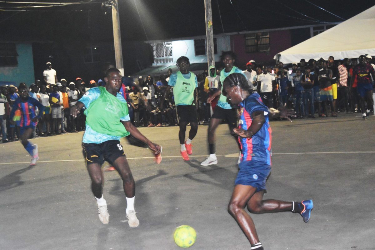 Calvin Moore (right) of North East La Penitence is trying to evade the impending challenge of Money’s William Europe during their semi-final encounter.