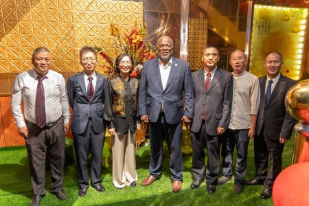 Prime Minister Mark Phillips (fourth from left) and Chinese Ambassador to Guyana, Guo Haiyan (third from left) with members of the association. (Office of the Prime Minister photo)   