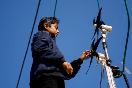 Displaced Palestinian teenager Hussam Al-Attar, nicknamed by people 'Newton', works on wind turbines, that he uses to light up his shelter during power cut, at a tent camp in Rafah, in the southern Gaza Strip, February 6, 2024. REUTERS/Ibraheem Abu Mustafa