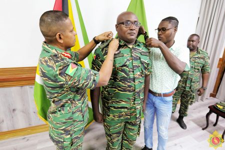 Gordon Nedd being badged. Chief of Staff of the GDF, Brigadier  Omar Khan is at left. (GDF photo)