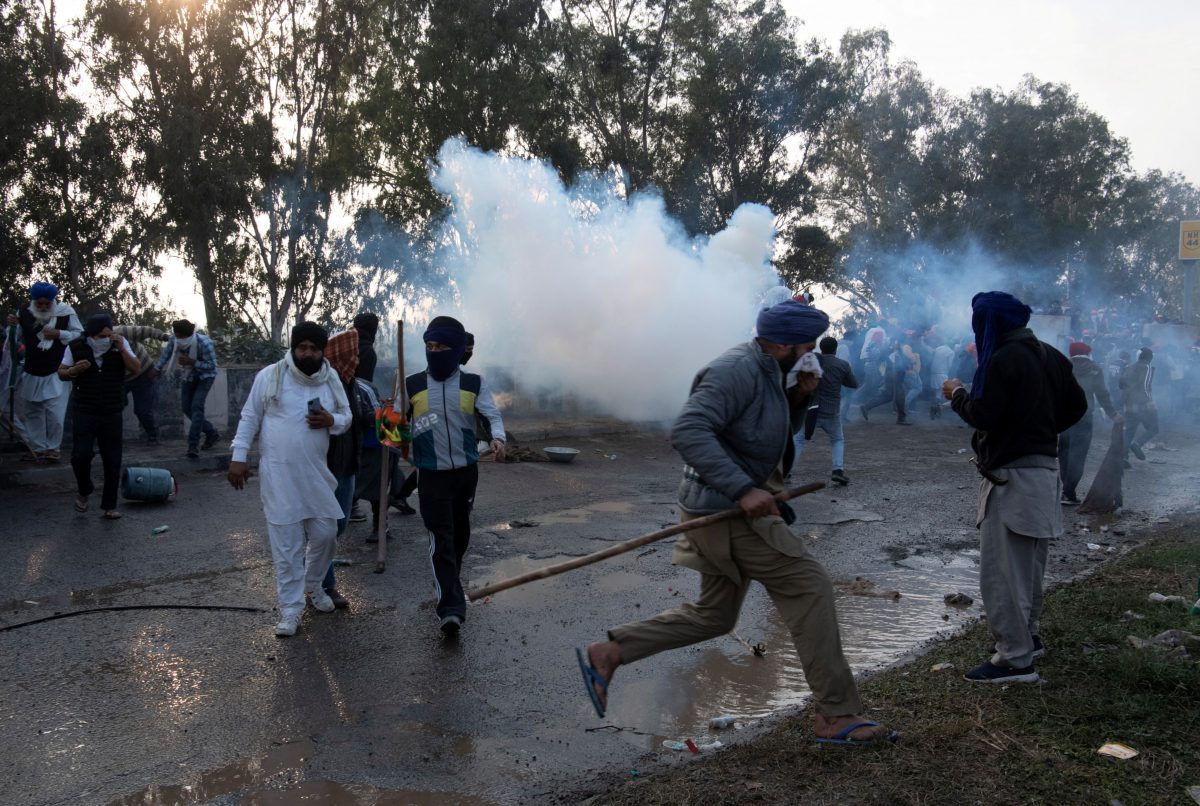 Farmers, who are marching towards New Delhi to press for the better crop prices promised to them in 2021, run for cover amidst tear gas smoke fired by police to disperse them at Shambhu, a border crossing between Punjab and Haryana states, India, February 13, 2024. REUTERS/Rohit Lohia/File Photo