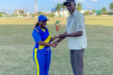 Demerara’s Roshana Harper receives her Player of the Match accolade from a GCB official.