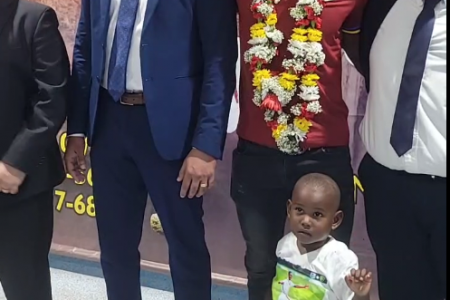 Shamar Joseph (centre) with his son flanked by Minister of Culture, Youth, and Sport, Charles Ramson (left) and Chairman of the CJIA Sanjeev Datadin.  