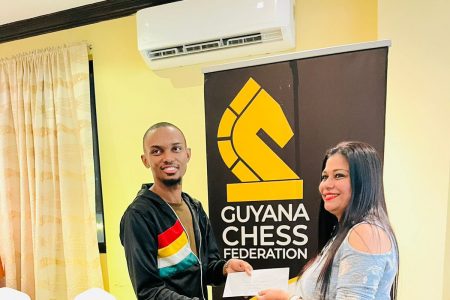 Anthony Drayton receives his prize after capturing the Caribbean Blitz Chess Championship.
