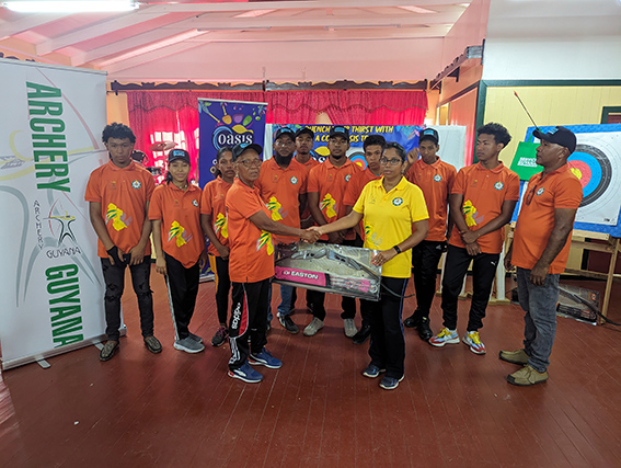 President of Archery Guyana Vidushi Persaud-McKinnon
presents the requisite equipment to Toshao Yvonne Pearson (left)
in the presence of the other members from ‘De Chief Archery Club’.
