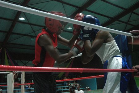 Ken Harvey (red) of Pace and Power Gym lands a left jab on Ronaldo Hunte of the Guyana Police Force Gym in the Juniors 56-59Kg final.