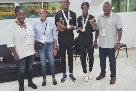 Golden Children! (2nd from right) Tianna Springer and Malachi Austin (centre) are posing with their spoils after winning the girl’s U-20 400m and boy’s U-20 400m gold medals, respectively. Missing from the photo is Athaleyah Hinckson in the girl’s U-17 100m. Also in the photo are Director of Sport Steve Ninvalle (right), NSC Vice-Chair Christy Campbell (4th from right), and Coach Trishel Thompson.
