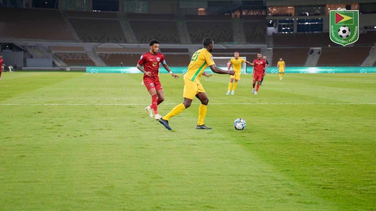 Colin Nelson (centre) of the Golden Jaguars is attempting to play out from the back while being pursued by a Cape Verde player