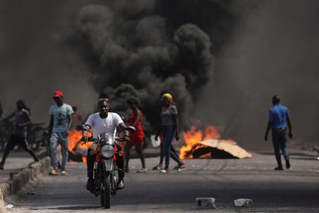 A man drives past a burning barricade during a protest against Prime Minister Ariel Henry’s government and insecurity, in Port-au-Prince, Haiti March 1, 2024. (Reuters photo)