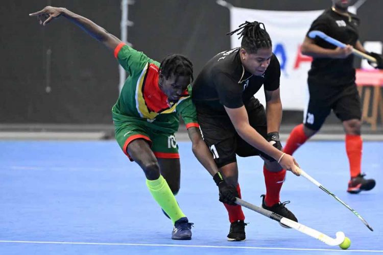 Jamarj Assanah (left) battles with Tariq Marcano of T&T during their group stage clash in the Indoor Pan American Cup
