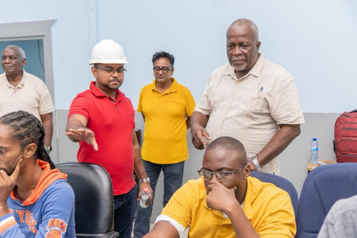 Prime Minister Mark Phillips (standing at right) getting an update from System Control and Operations Manager Navin Deonarayan (in helmet) (Office of the Prime Minister photo)