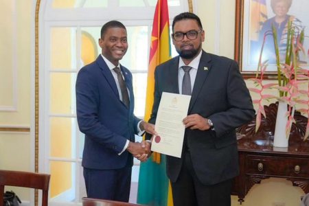 President Irfaan Ali (right) handing over the document of accession on December 6, 2022 to the Chair of the Ministerial Council of the RSS, Prime Minister of Grenada, Dickon Mitchell. (Office of the President photo)